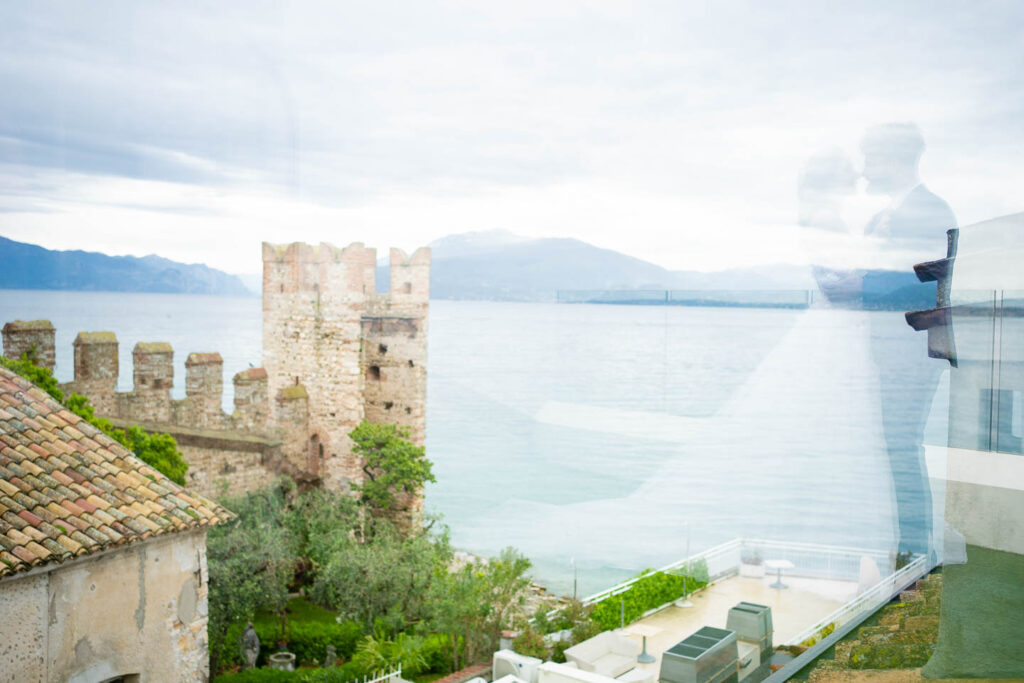 Großes Lächeln, aufrichtiger Moment Braut und Bräutigam am Gardasee. Professioneller Hochzeitsfotograf Wien. Kunst