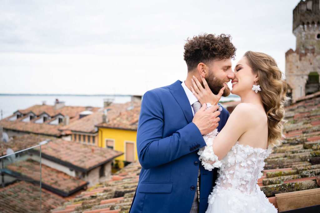 Großes Lächeln, aufrichtiger Moment Braut und Bräutigam am Gardasee. Alte gebaude Professioneller Hochzeitsfotograf Wien.