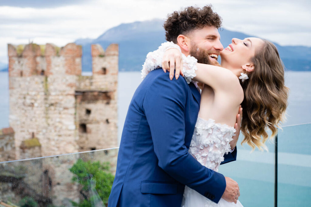 Großes Lächeln, aufrichtiger Moment Braut und Bräutigam am Gardasee. Professioneller Hochzeitsfotograf Wien.