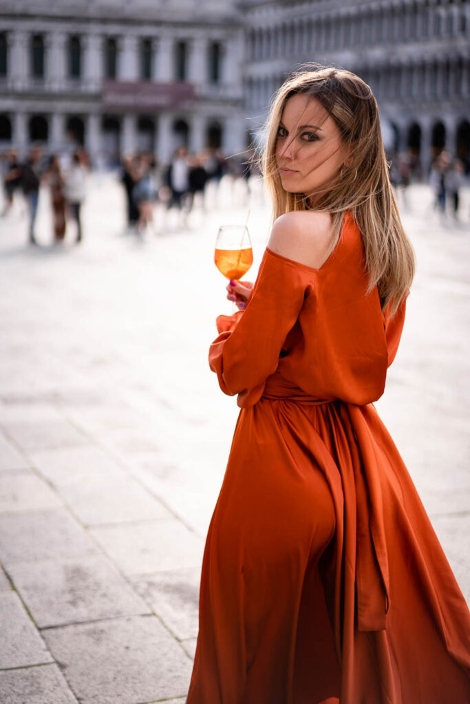 Wunderschöne Brautjungfern trinken Aperol in farbigen Kleidern in Venedig, Italien Hochzeisfotograf