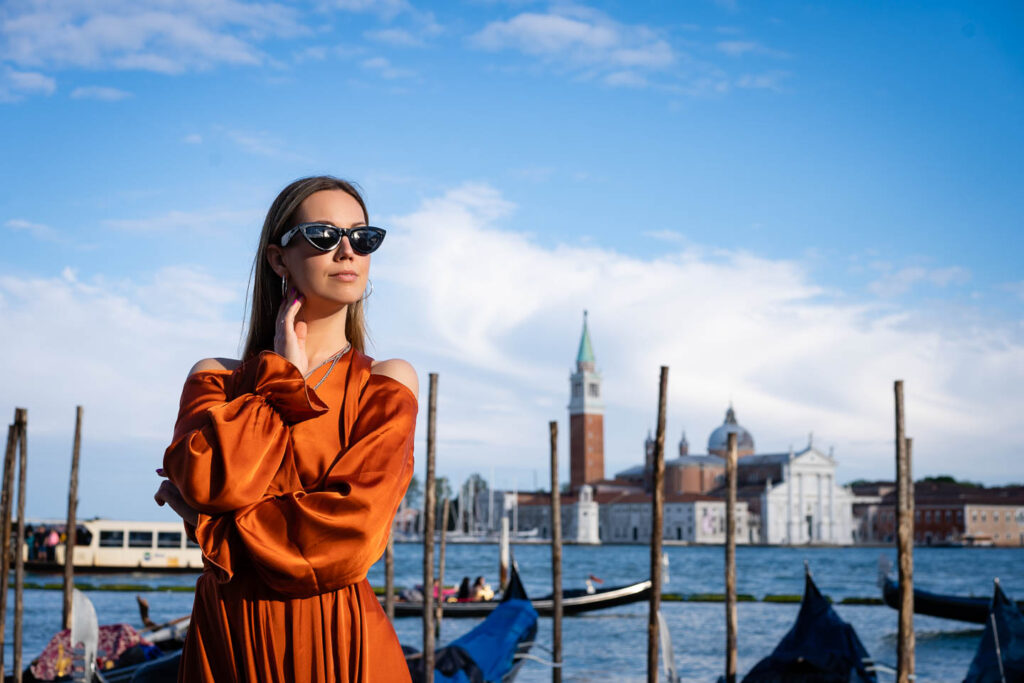 Beautyfull woman wear sunglasses in Venice Italy next to the see and boats Hochzeitsfotograf