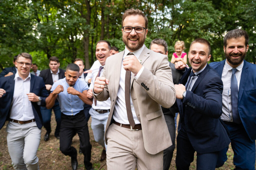 Der Bräutigam und die Freunde des Jungen auf einem lustigen, bewegenden, lebhaften Gruppenfoto. Ein besonders lustiges Foto. Hochzeitsfotograf Wien