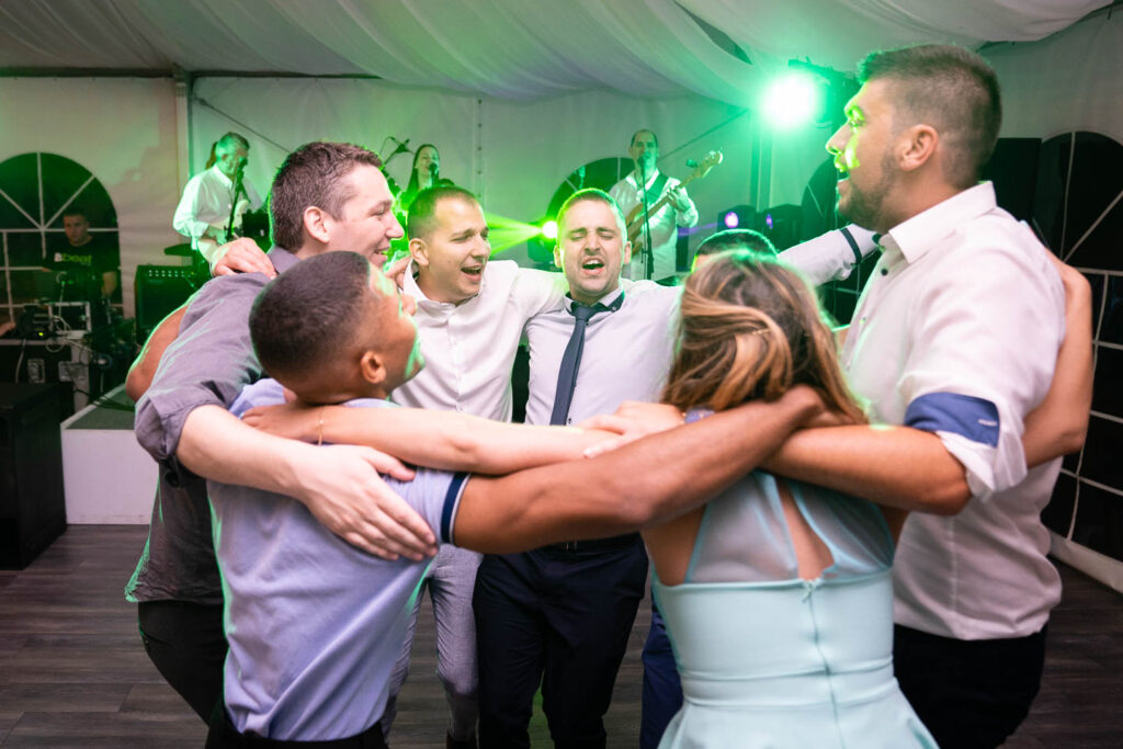 Eine große Party nach der Hochzeit mit wunderschöner Beleuchtung. Alle singen. Hochzeitsfotograf Wien
