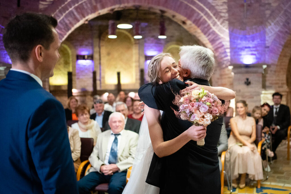 Die Braut umarmt ihren Vater, nachdem sie ihn zur Hochzeit eingeladen hat. Ein besonderer Moment. Hochzeitsfotograf Wien