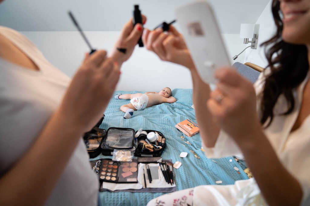 Ein besonderes Bild vom Make-up der Braut, während sich im Hintergrund ein Kind schlecht benimmt. künstlerisch eingefangener Moment Hochzeitsfotograf Wien