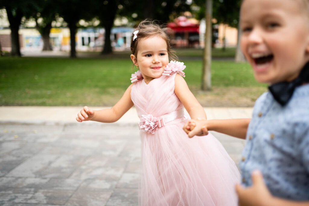 Die jüngste Brautjungfer und ein kleiner Junge rennen zur Hochzeit. Hochzeitsfotograf Wien