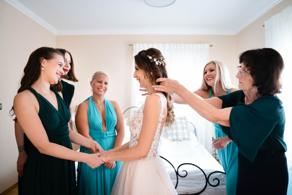 Die Braut und ihre Freundinnen bereiten sich gemeinsam auf die Hochzeit vor. Großes Lachen, eingefangener Moment. Hochzeitsfotograf Wien