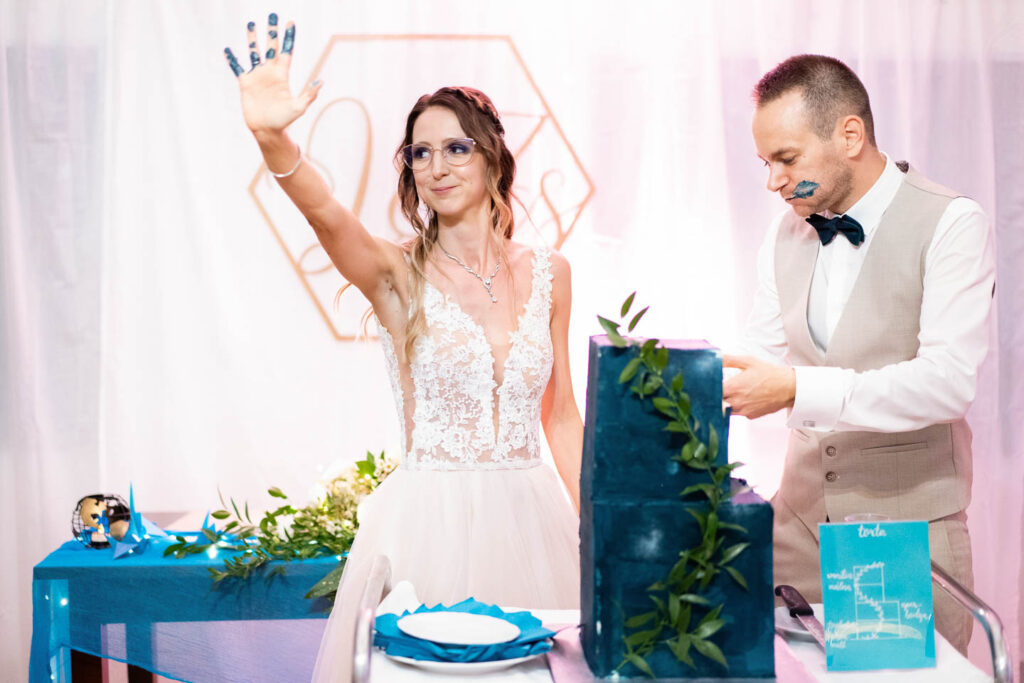 Extrem blaue Hochzeitstorte. Sowohl die Hände der Braut als auch das Gesicht des Bräutigams wurden blau. Hochzeitsfotograf Wien