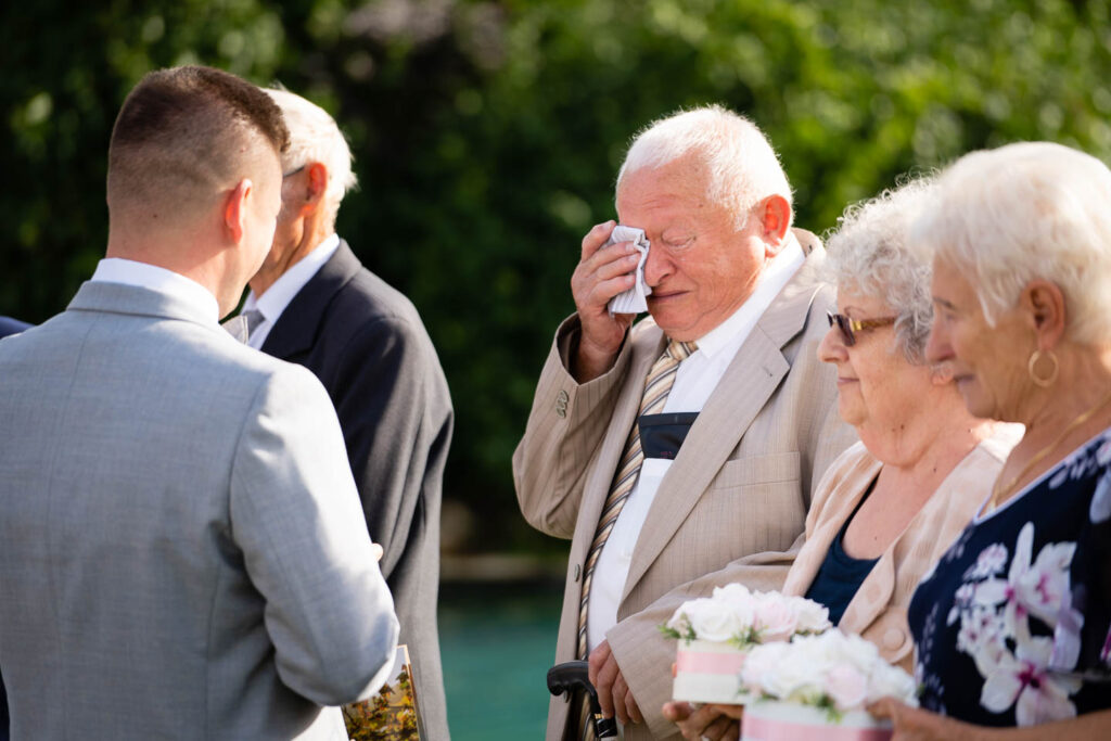 Berührter Großvater wischt sich bei der Hochzeit die Tränen weg. Ein meisterhaft eingefangener Moment. Hochzeitsfotograf Wien