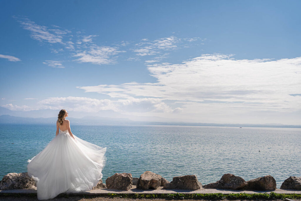 Braut in lange hochzeitskleid vor dem Garda see. Professionelle hochzeit fotograf