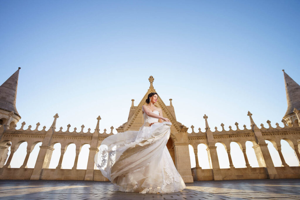 Bride turning arounds with the bridal dress in sunrise by a beautyfull castle. Professional wedding phtographer