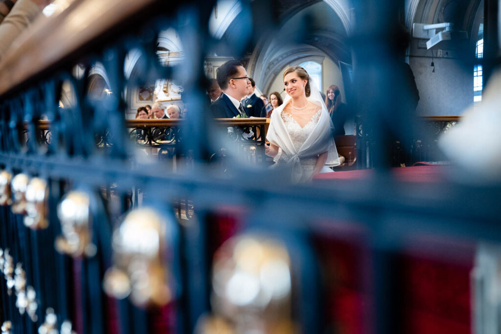 Braut und Bräutigam schauen sich in der Kirche an. Eine besondere künstlerische Perspektive. Hochzeitsfotograf Wien
