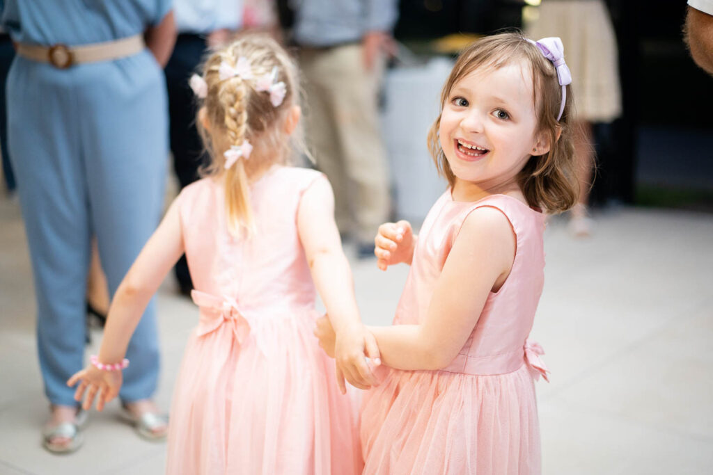 Lachendes kleines Mädchen auf der Tanzfläche bei der Hochzeit. Hochzeitsfotograf Wien