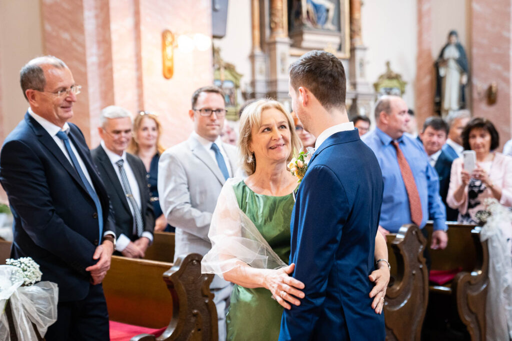 Seine Mutter nimmt den Bräutigam zur Hochzeit mit in die Kirche. Hochzeitsfotograf Wien